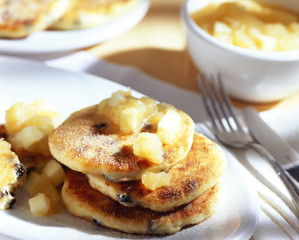 Sweet curd cheese fritters on a plate with flatware