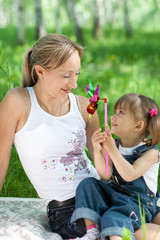 Mother and daughter in jeans with toy outdoor