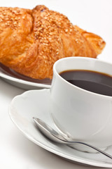 Breakfast: coffee and croissant with sesame seeds