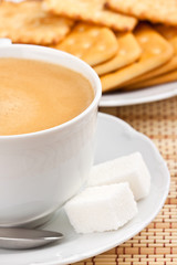 Breakfast: a cup of  coffee with a lump sugar and crackers