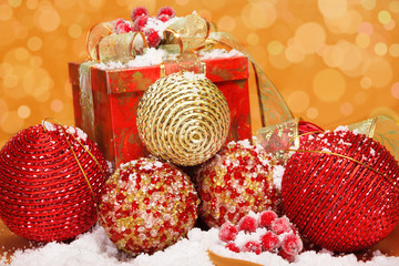 Box with golden and red balls covered with snow