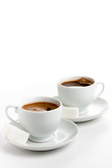 Two cups of coffee with sugar cubes