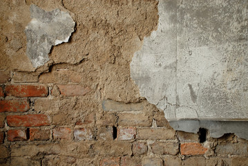Grungy wall of plaster and brick crumbling.