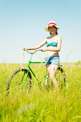 Fototapeta na wymiar girl riding bicycle in grass