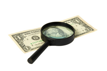 Money and magnifying glass isolated on white background