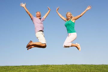 Senior couple jumping in air - Powered by Adobe