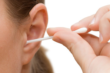 A woman cleaning her ear with cotton swab