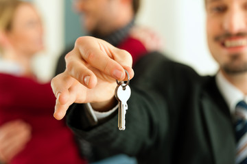 Paar erhält Schlüssel zur Wohnung von Makler
