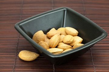 almonds in a bowl on a bamboo mat
