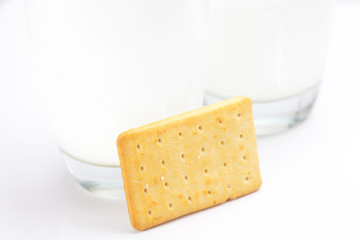 two glasses of milk and cookies on a gray background