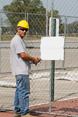 Worker Posting Blank Sign