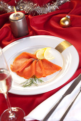 Lachs zu Weihnachten auf festlich dekoriertem Tisch mit Kerze