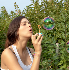 attractive girl blowing soap bubbles