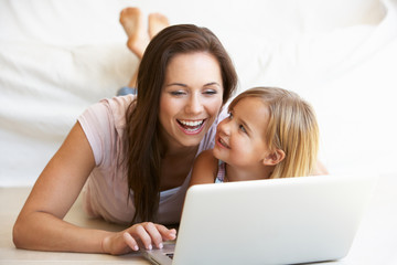 Young woman with girl using laptop computer