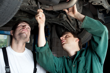 Car Mechanics repairing car - obrazy, fototapety, plakaty