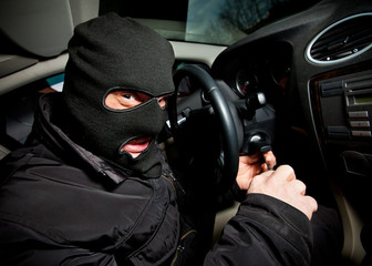 robber and the thief in a mask hijacks the car