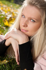 Naklejka premium Portrait of young beautiful woman in the autumn park