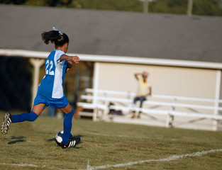 girl chasing soccer ball