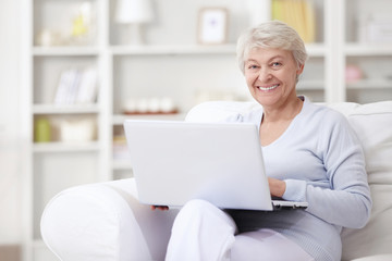 An elderly woman with a laptop