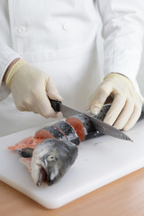 Cook cutting a fish