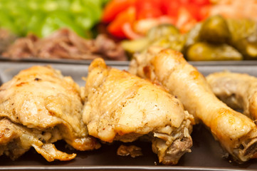 fried chicken served with vegetables in the background