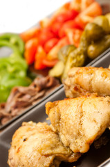fried chicken served with vegetables in the background
