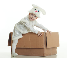 The boy in a suit of a rabbit gets out of a box