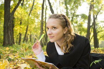 Inspired teenager girl in autumn park