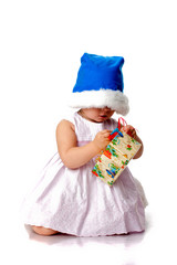 Beautiful baby in Santa's hat with a present