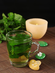 Fresh mint tea with cookies, stones, and a candle