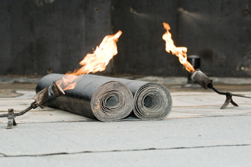 tar roofing felt roll and blowpipe with flame