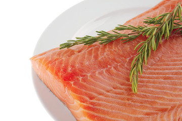 fresh uncooked salmon fillet on plate with rosemary