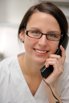 Zahnarzthelferin telefoniert mit einem Patienten