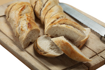 sliced french bread on wooden chopping board with a knife