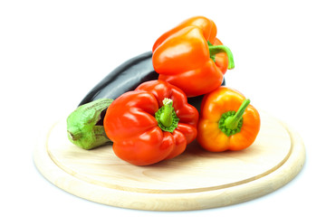 Fototapeta na wymiar red pepper and eggplant on a cutting board isolated on white