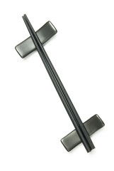 Two black wodden chopstick on holder over white