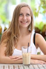 Young woman drinking coffee in a cafe outdoors