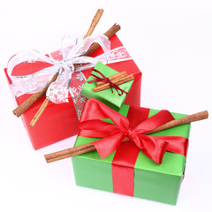Gift with bows decorated with cinnamon sticks on white