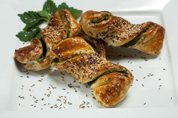pastry with spinach on white plate isolated