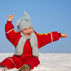 Cute blond child is playing in the snow
