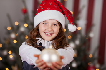 mädchen mit nikolausmütze und christbaumkugel