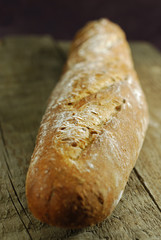 An entire floured french baguette close up