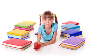 Child with pile of books reading on floor.