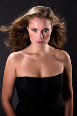 Naklejka premium Young beautiful woman with long curly hairs isolated on black