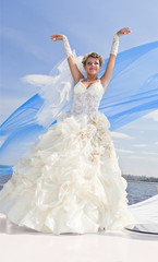 Fototapeta na wymiar happy bride on the yacht, the blue sky