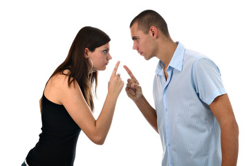 Young couple pointing fingers at each other isolated on white