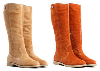 Two pairs of female high boots on the white background