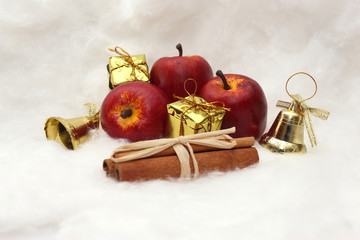 Apfel, Zimt, Geschenk und Glöckchen zur Weihnachtszeit