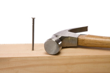 hammer and nail isolated on wood brick on white