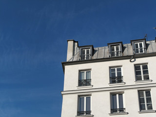 Fototapeta na wymiar Immeuble blanc parisien et ciel bleu.
